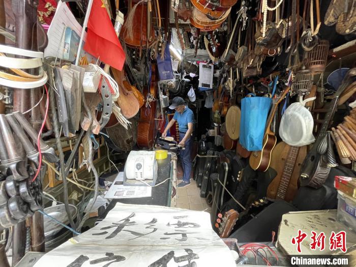 小店的顶部、墙壁等处密密麻麻地挂着冯顺成的乐器宝贝，足有上百把琴。　康玉湛摄